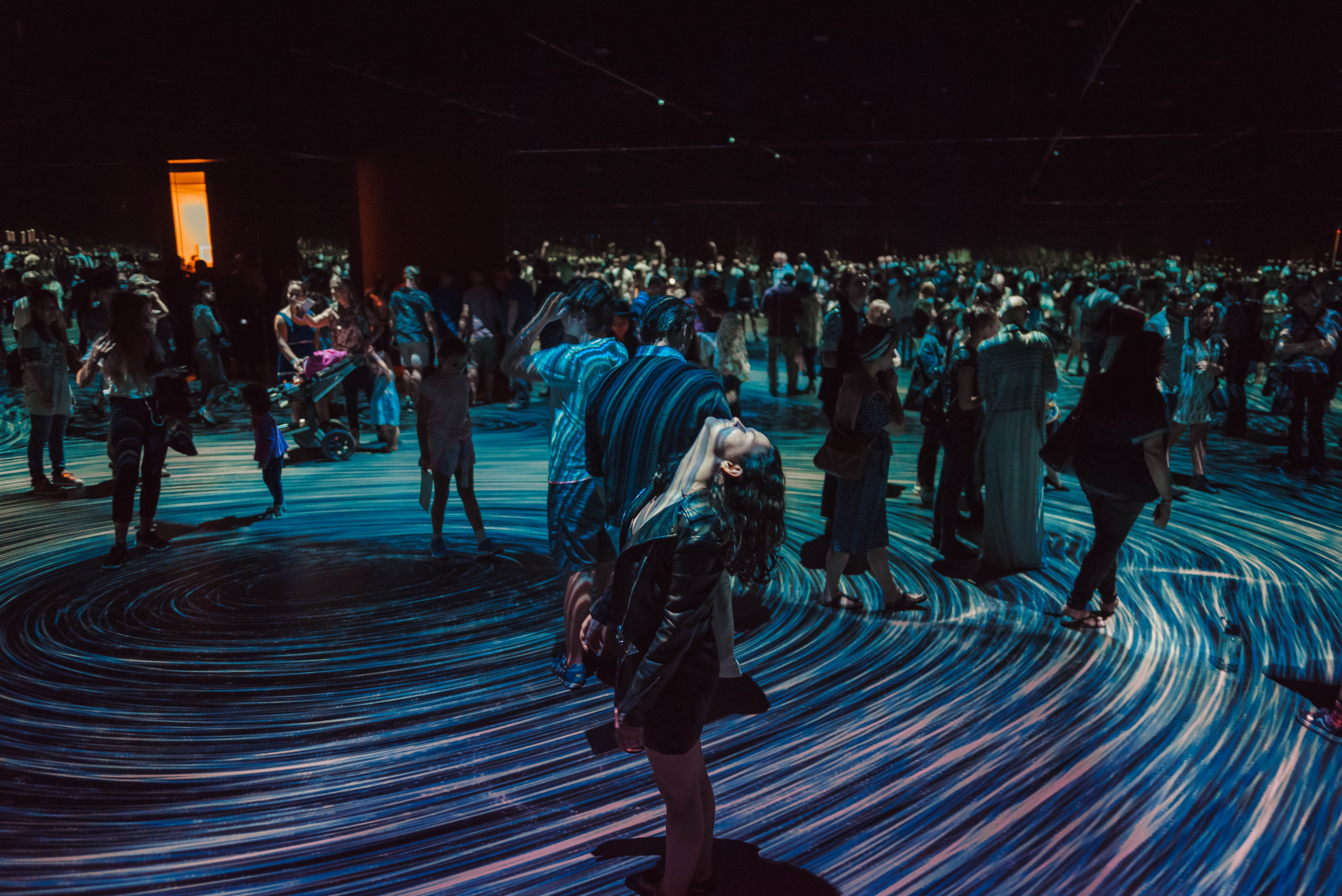 woman standing in the middle of a large image projection on the floor